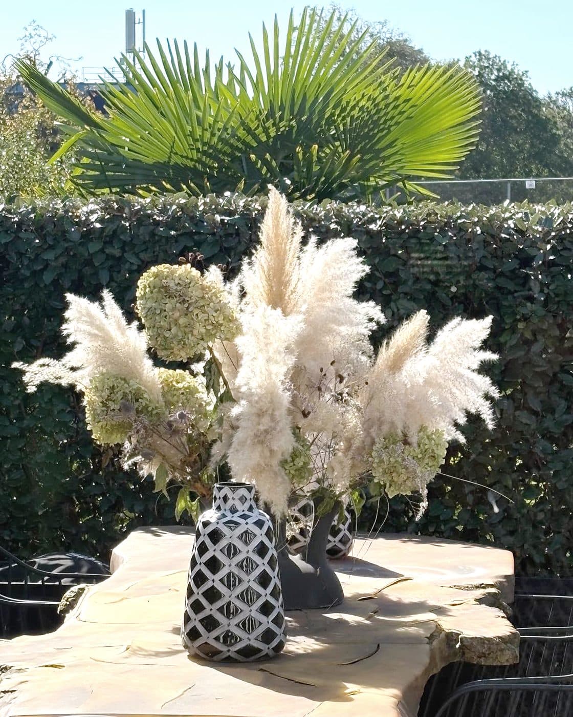 Boeket van pampasgras en hortensia op een houten terrastafel